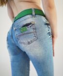 Jeans with scuffs and a green belt