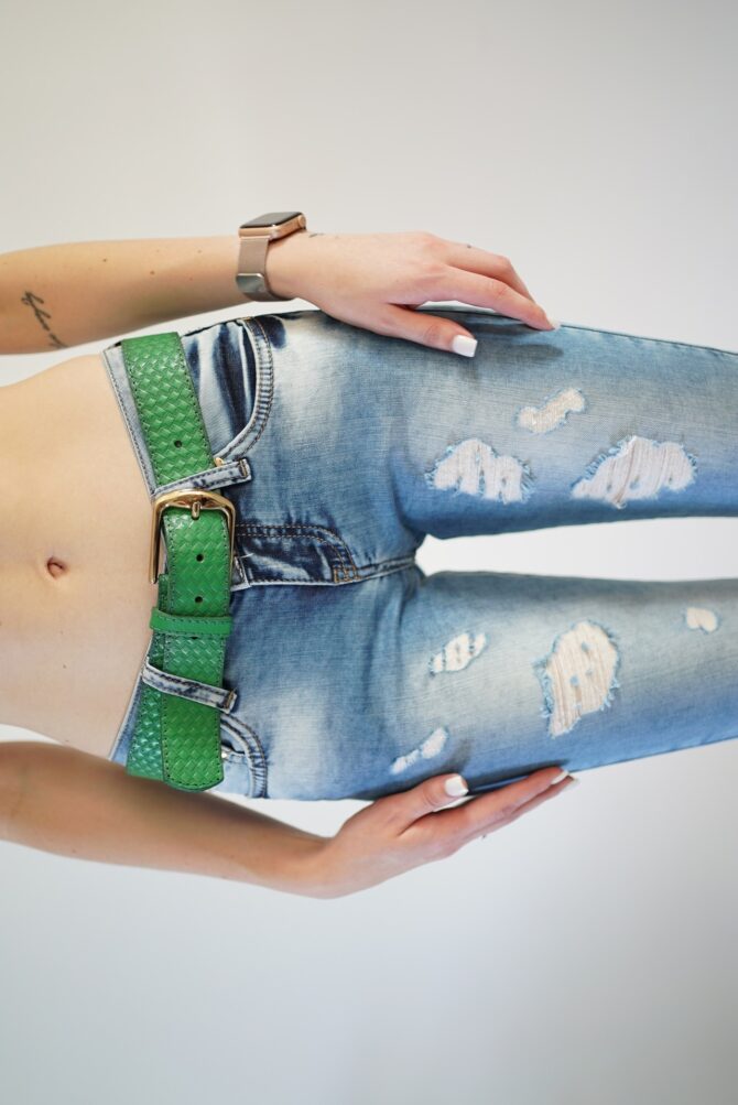 Jeans with scuffs and a green belt