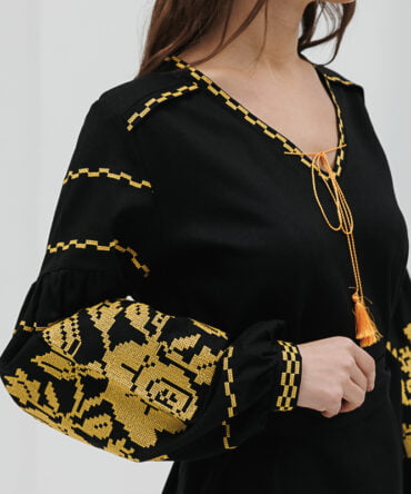 Black short embroidered dress with yellow cross-stitched roses on the sleeves.