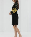 Black short embroidered dress with yellow cross-stitched roses on the sleeves.