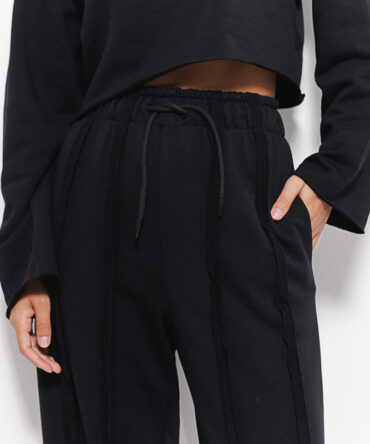 Women's black tracksuit with inside-out seams.