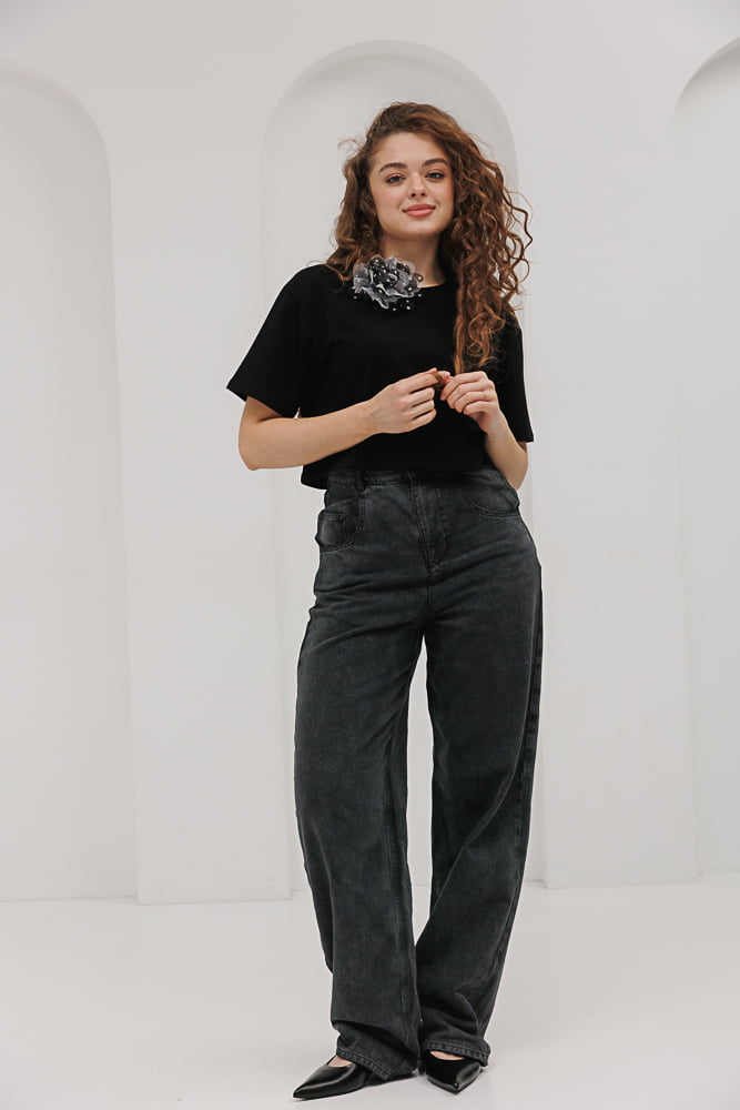 Women's oversized black t-shirt with a flower brooch.