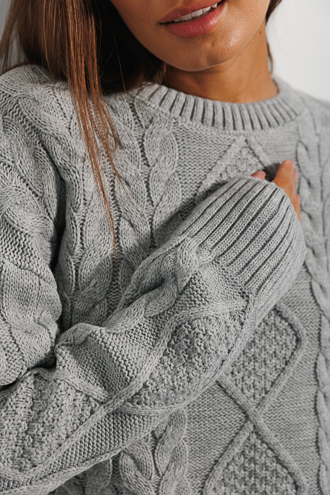 Cropped light grey knit jumper with ties at the bottom.