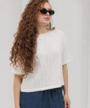 Light milk-colored women's knitted t-shirt with lace patterns.