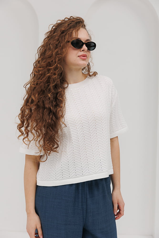 Light milk-colored women's knitted t-shirt with lace patterns.