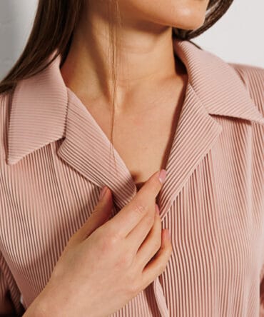 Women's pleated shirt in light beige with short sleeves.