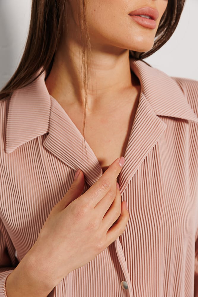 Women's pleated shirt in light beige with short sleeves.