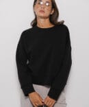 Women's black oversized sweatshirt with a shaped cuff.