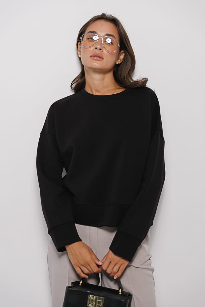 Women's black oversized sweatshirt with a shaped cuff.