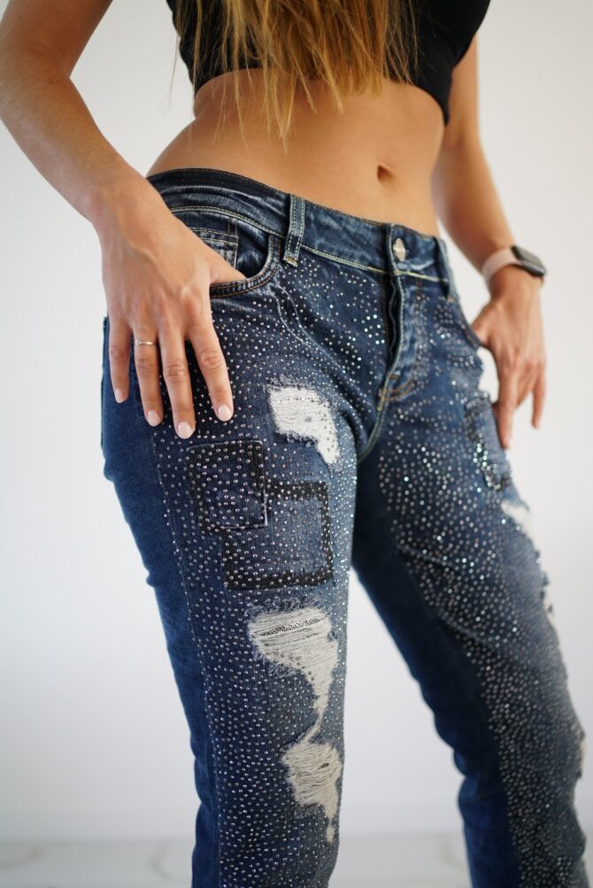 Frayed jeans with rhinestones on the front and on caramnes