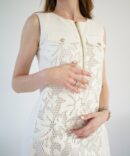 White lace dress with gold clasp on the front