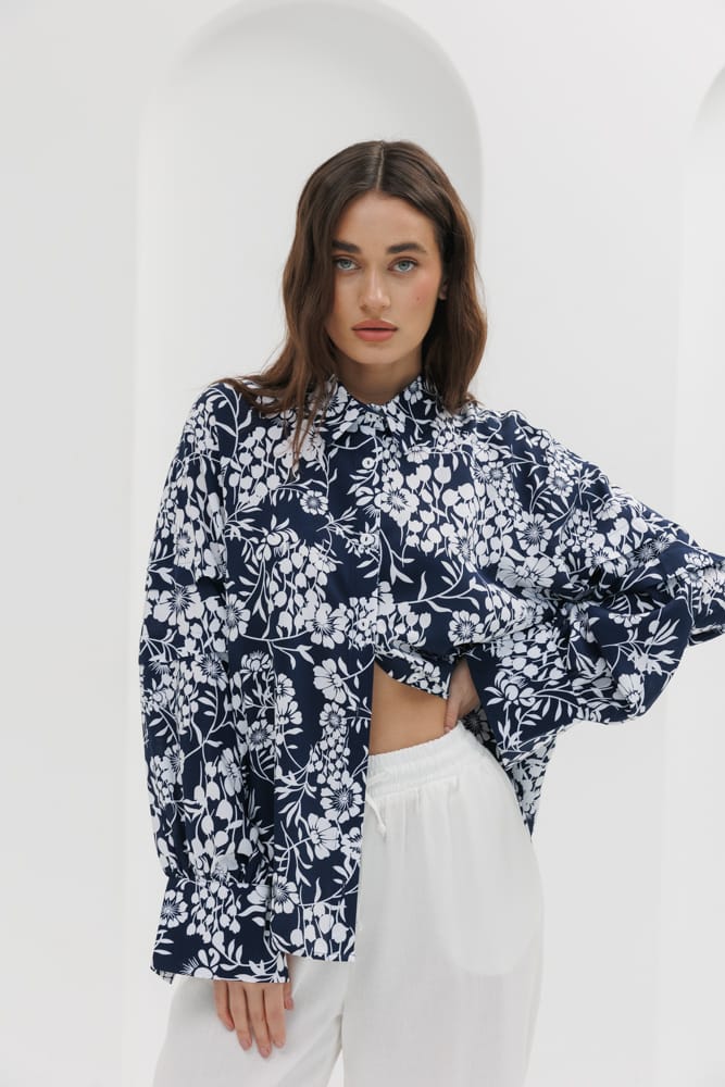 Women's dark blue blouse with pleats on the sleeves and floral print.