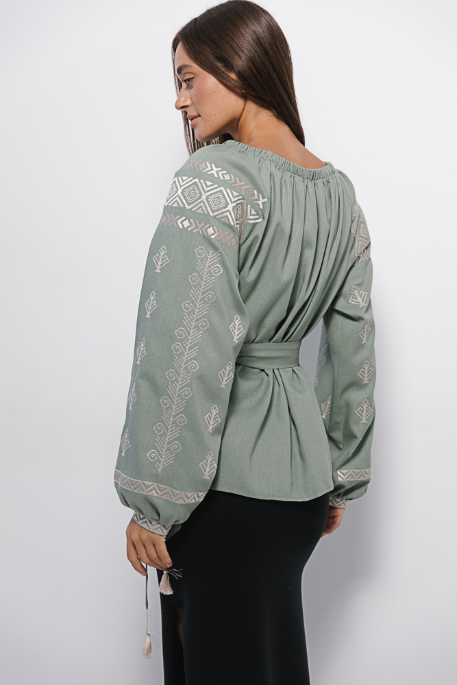 Women's olive embroidered shirt with off-shoulder design and geometric satin stitch pattern.