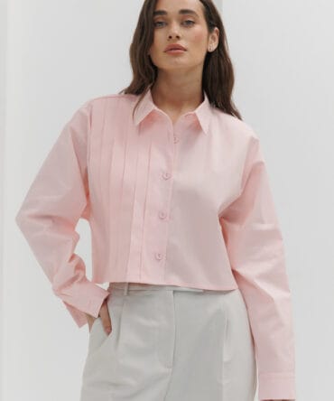 Cropped pink women's shirt with pleats on the right.