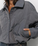 Cropped women's graphite transitional quilted jacket with wavy stitching.