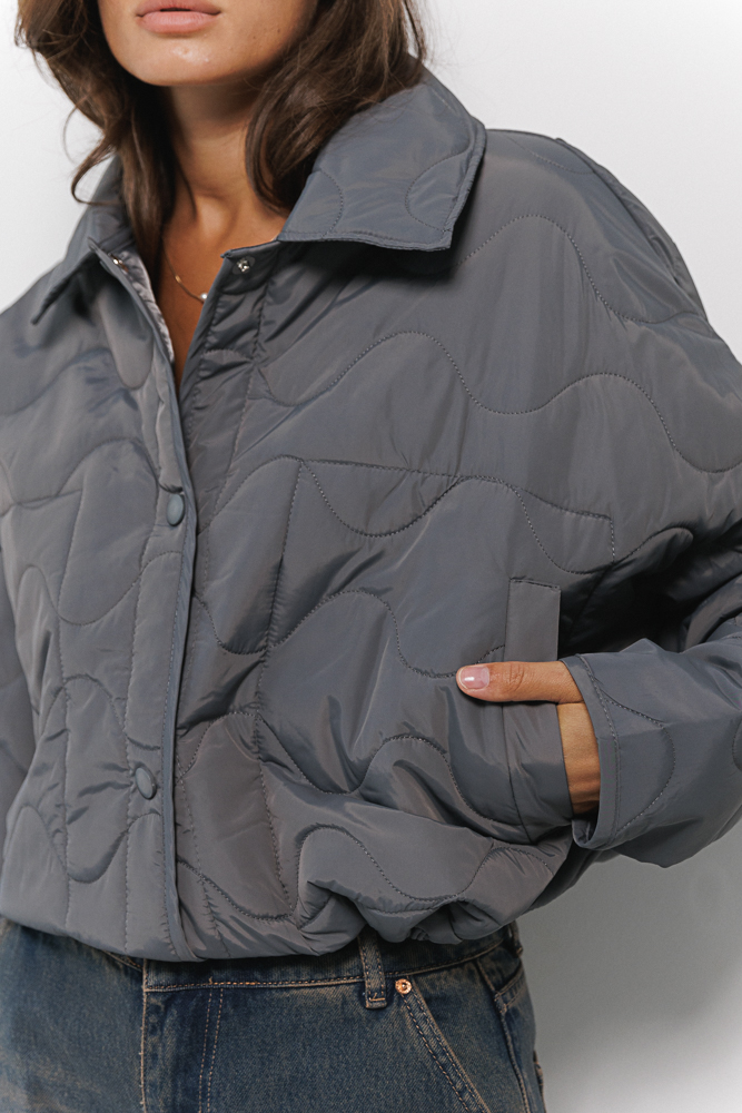 Cropped women's graphite transitional quilted jacket with wavy stitching.