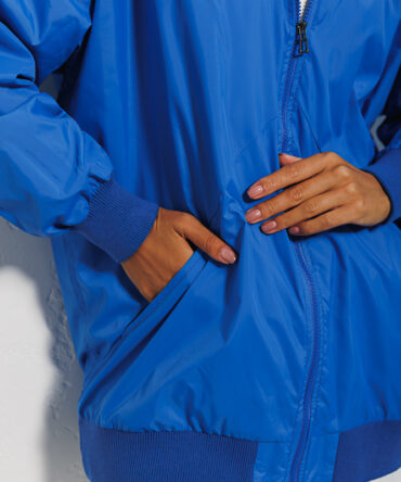 Elongated blue women's windbreaker with a pocket on the sleeve