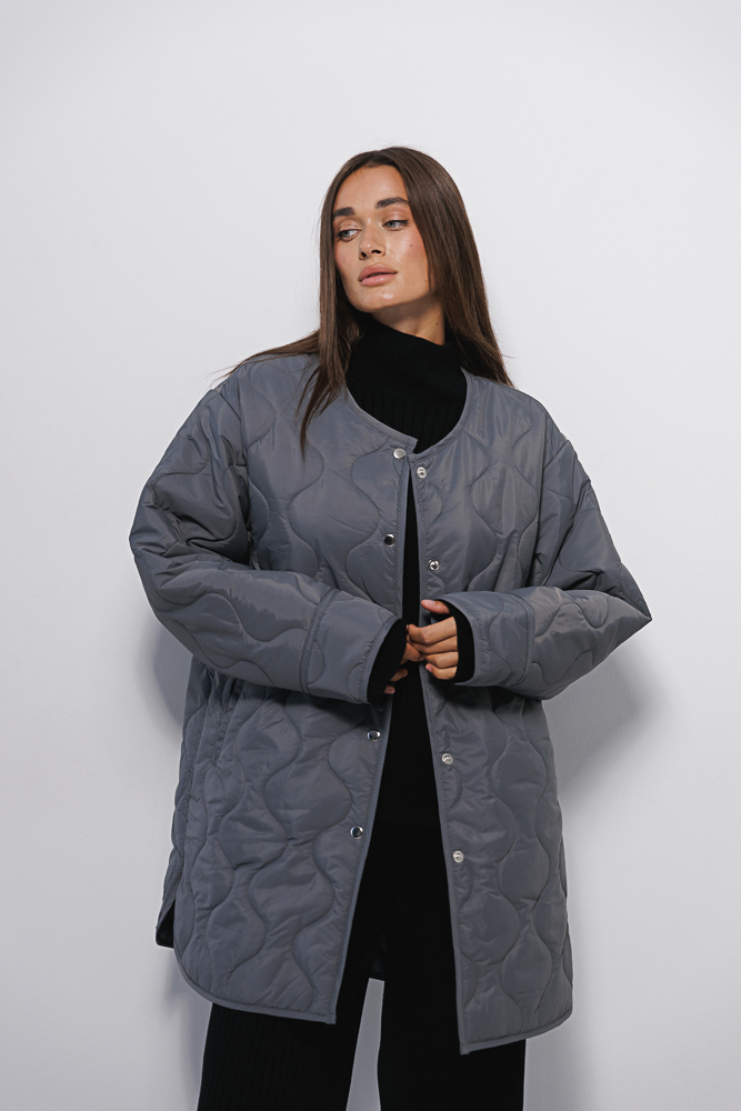 Women's elongated graphite quilted jacket with a wave pattern.