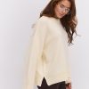 Жіночий в`язаний джемпер oversize темно-молочний з розрізами внизу